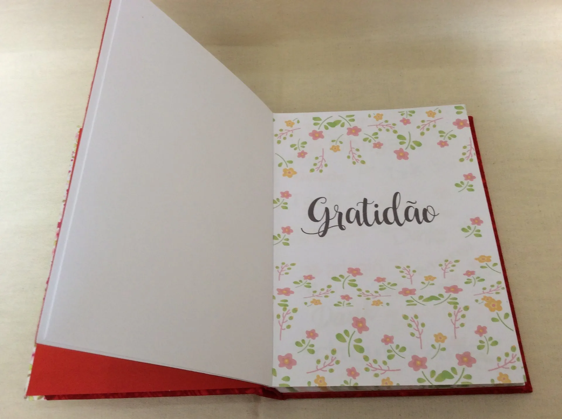 Caderno aberto com a palavra Gratidão escrita na capa florida