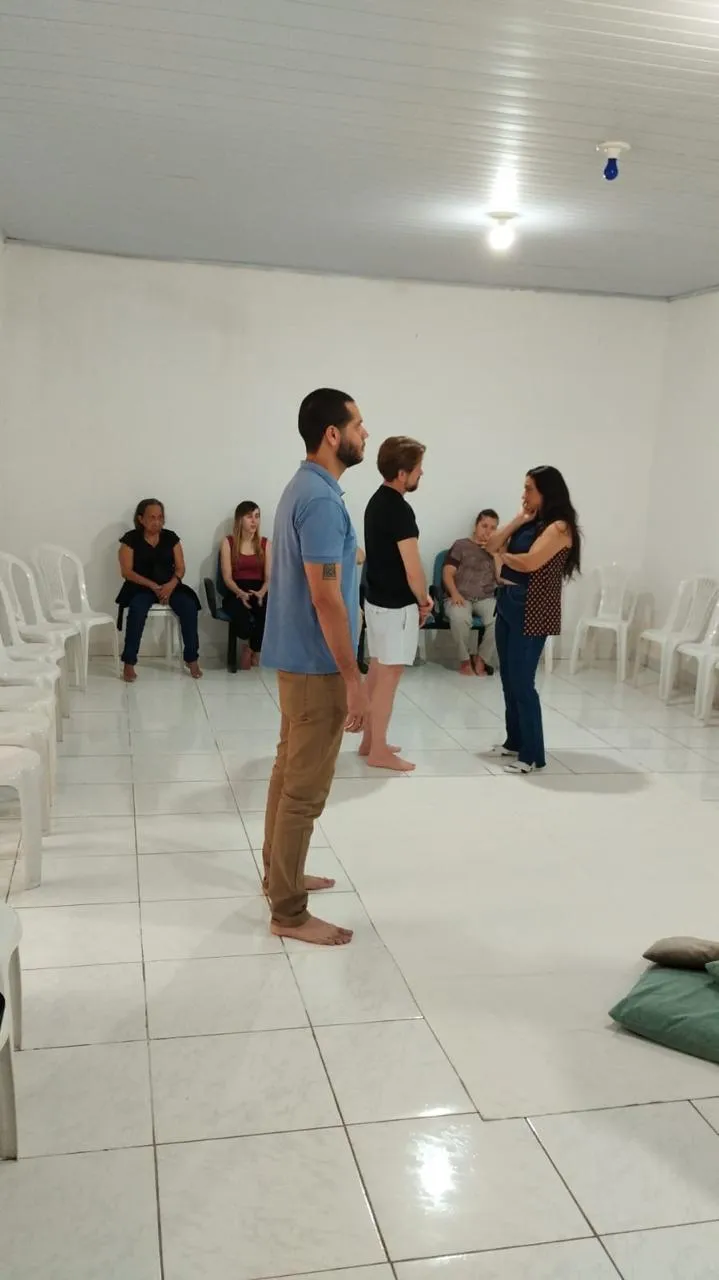 Constelação em andamento: representantes em pé no centro da sala enquanto o grupo observa